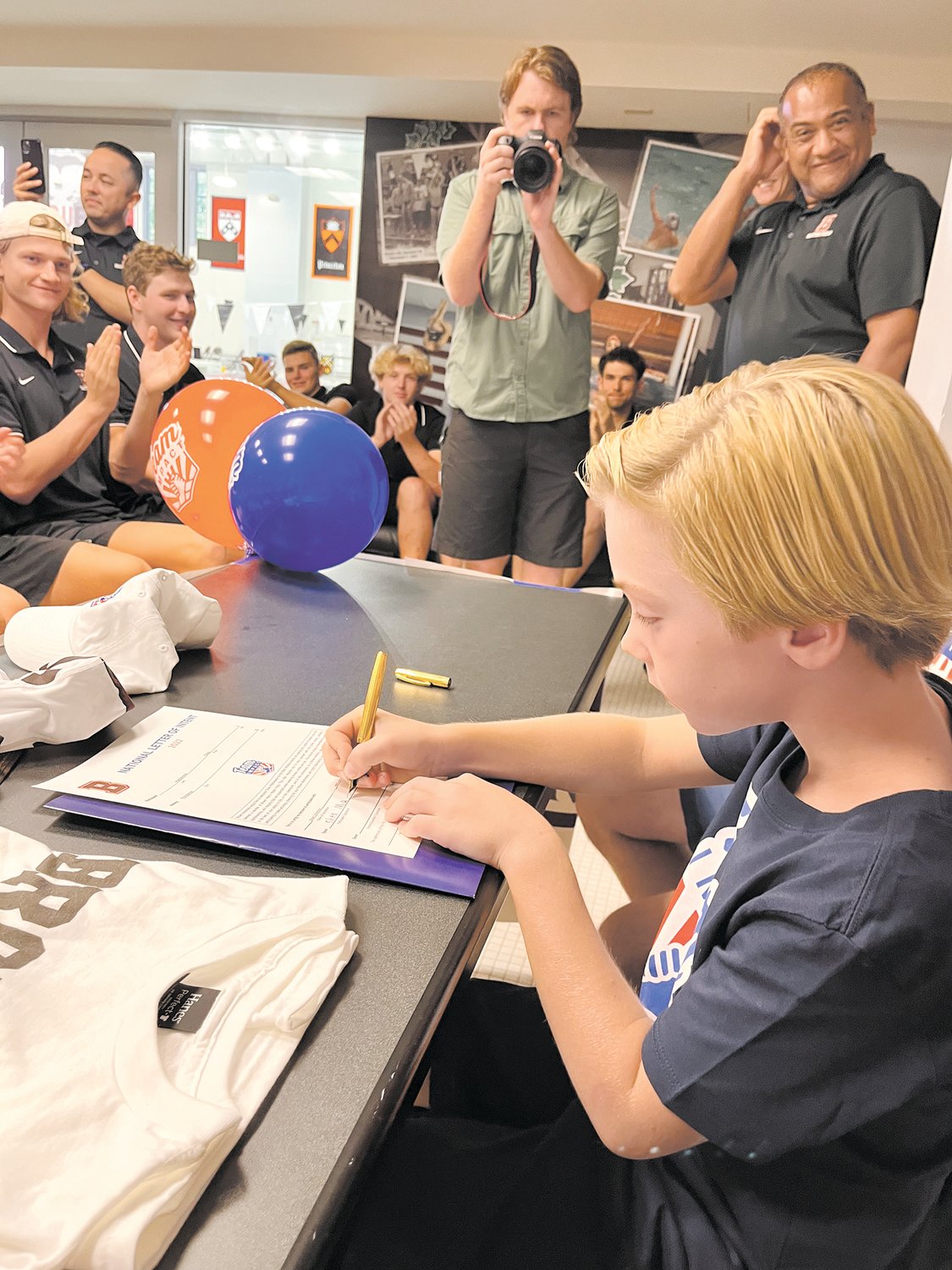IT’S OFFICIAL: Shea Mathewson signed on as a member of the Men’s Water Polo team through Team IMPACT on Sept. 10. Men and women from Brown University’s Water Polo team cheered him on at the event.